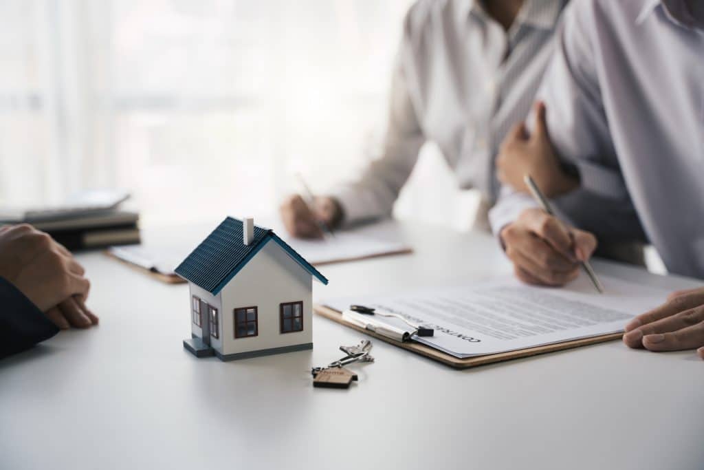 mortgage loans agreement signing with miniature house model