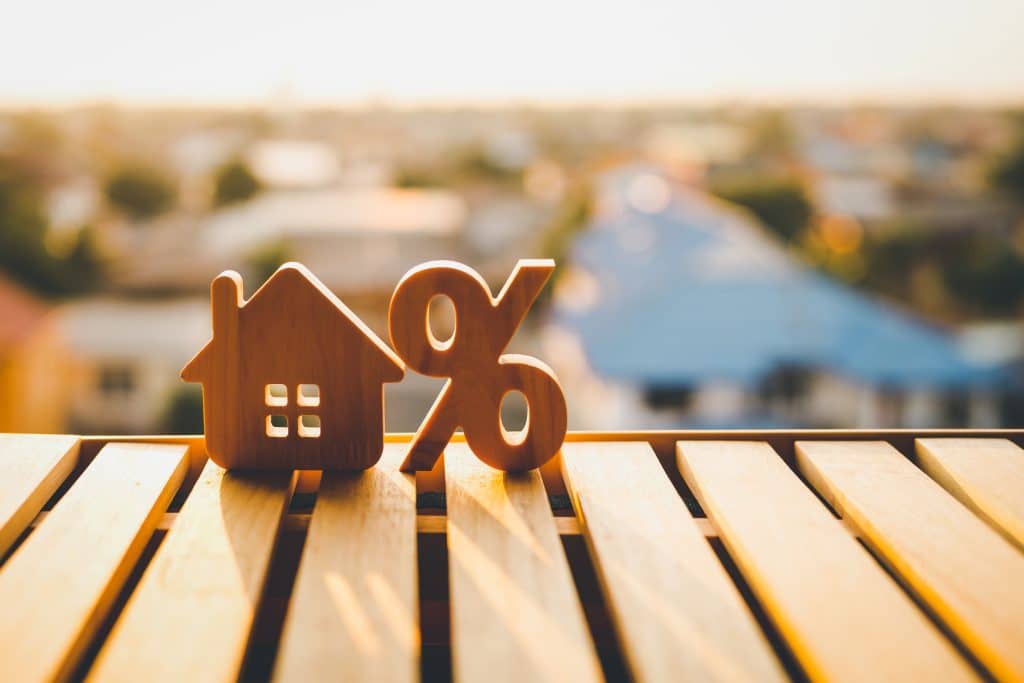 wooden house model with percentage sign for mortgage loans