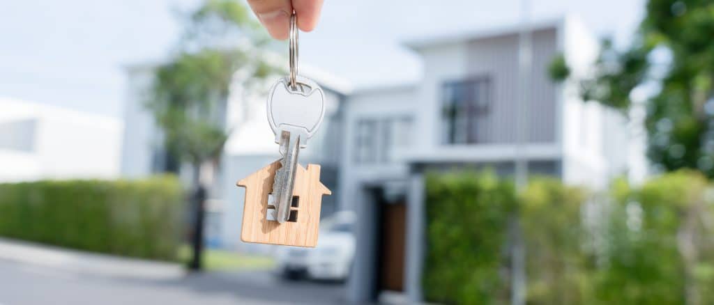 hand holding house key, symbolizing mortgage loan