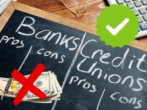 chalkboard comparing banks and credit unions with check mark highlighting credit unions.