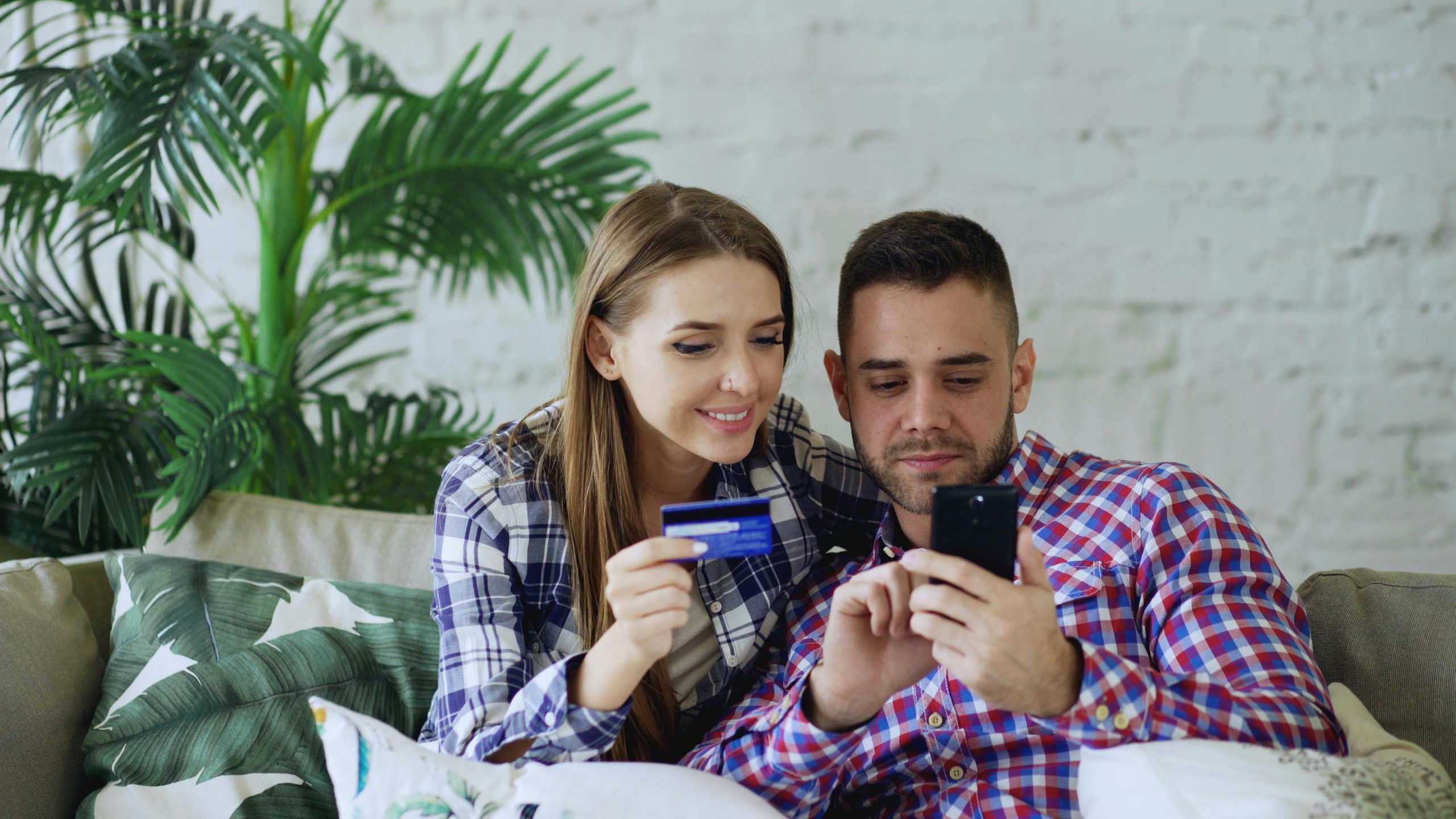 man and woman sitting on white couch